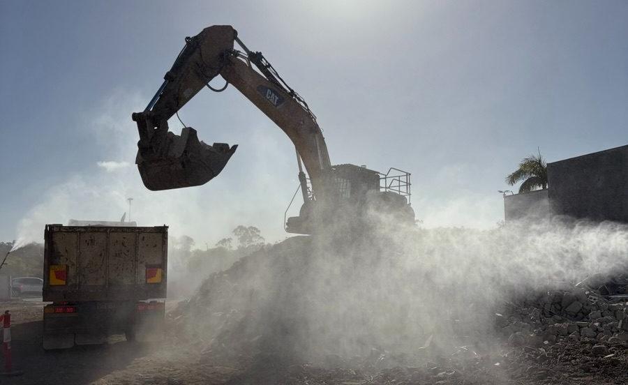 Excavator in a dust plume at Grand Plaza